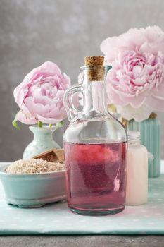 Flakon na tle różowych kwiatów