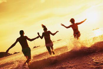 Grupa przyjaciół wbiegająca do morza