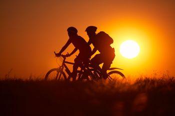 Kolarze na tle zachodzącego słońca
