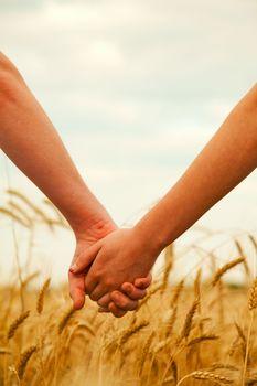 Para trzymająca się za ręce na polu