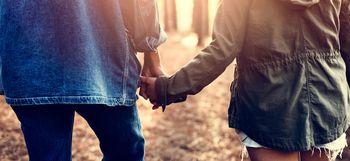 Para trzymająca się za ręce w lesie