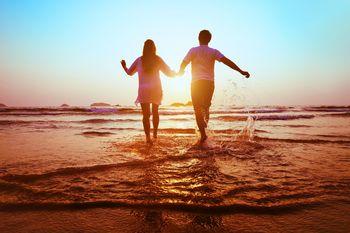 Para wbiegająca do morza o zachodzie słońca