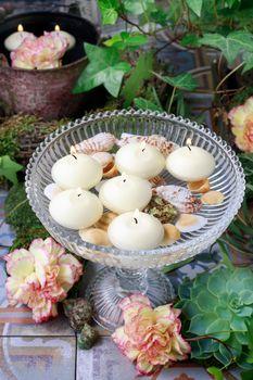 Pływające świece w misce z muszlami