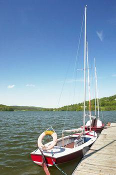 Żaglówka w przystani nad jeziorem