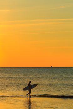 Człowiek spacerujący z deską surfingową