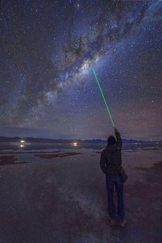 Człowiek wskazujący laser w centrum galaktyki
