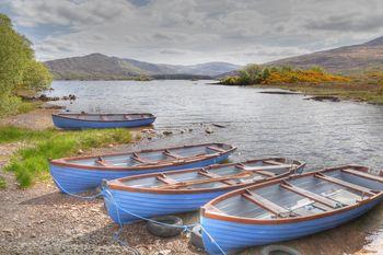 Trzy niebieskie łodzie nad jeziorem. Irlandia, Wyspy Brytyjskie, Europa