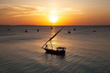 Łódź na tle zachodzące słońca