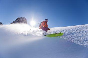 Mężczyzna zjeżdżający na desce snowboardowej