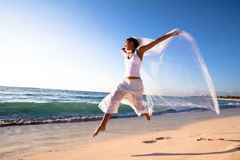 Młoda kobieta podskakująca na plaży