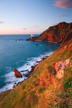 Morskie klify z oddalona w tle latarnia morską. Anglia