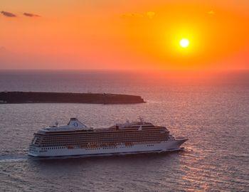  Statek wycieczkowy na tle zachodzącego słońca, Thera, Grecja.
