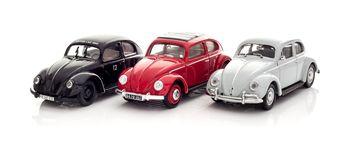 Trzy metalowe garbusy na białym tle