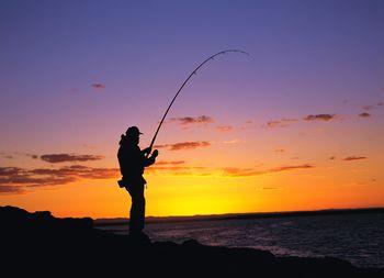 Wędkarz na tle zachodzącego słońca