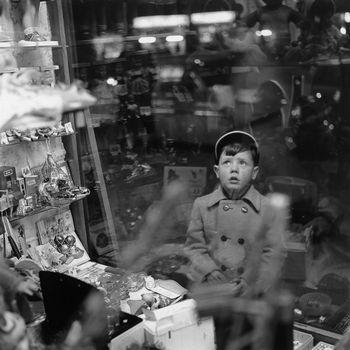 Chłopczyk patrzący się na witrynę sklepową