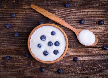 Jogurt naturalny z borówkami w drewnianym naczyniu