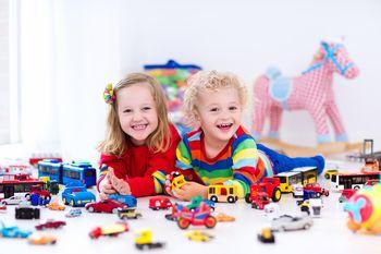 Dwójka dzieci bawiąca się zabawkami na podłodze