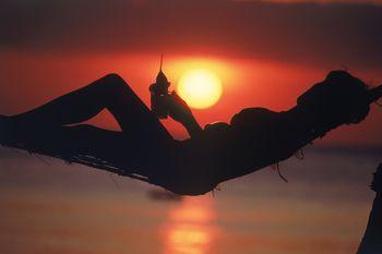 Kobieta pijąca drinka na hamaku