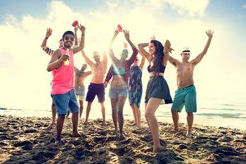 Grupa przyjaciół imprezująca na plaży