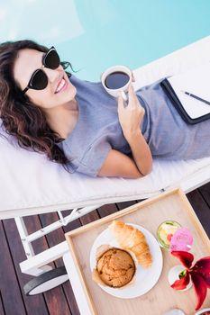 Kobieta jedząca śniadanie nad basenem