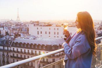 Kobieta pijąca szampana na balkonie w Paryżu
