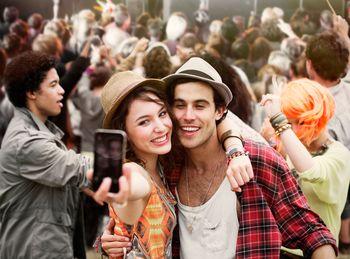 Para robiąca sobie selfie na koncercie