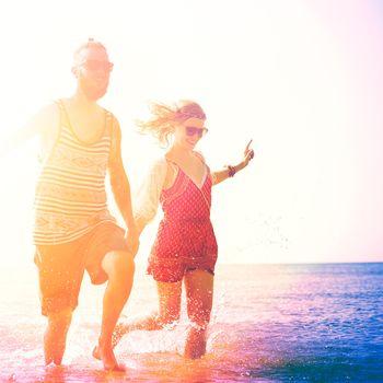 Para biegnąca brzegiem morza