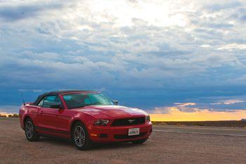 Czerwony Ford Mustang na tle chmur