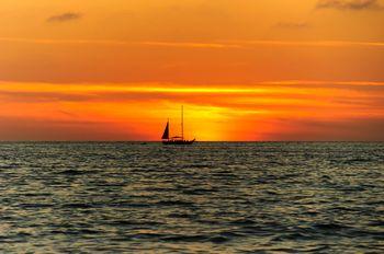 Żaglówka na morzu na tle zachodzące słońca