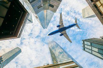 Samolot przelatujący nad wieżowcami