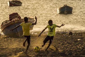 Chłopcy grający w piłkę na plaży