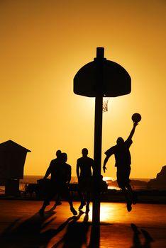 Mecz koszykówki przy zachodzie słońca