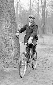 Mężczyzna na rowerze oparty o drzewo